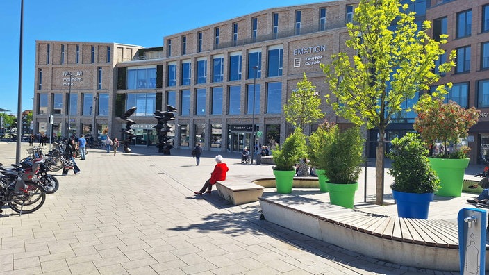 Menschen halten sich auf dem Ingeborg-Friebe-Platz in Monheim auf