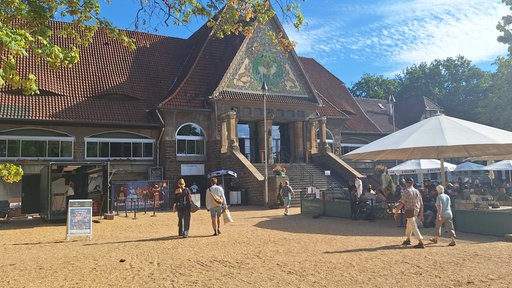 Ein großes altes Haus mit Treppe und Menschen