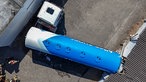 Der Anhänger des Tanklasters ist quer zwischen Garagen und einem Gebäude verkeilt
