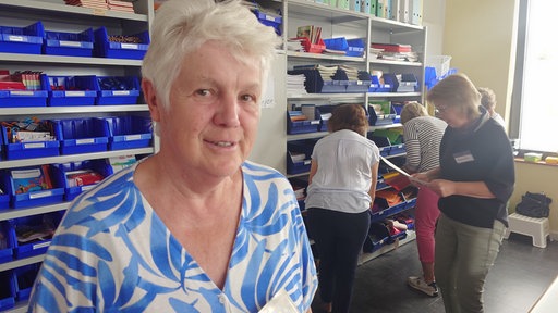 Ein Frau in einem weiß-blauen Oberteil lächelt in die Kamera