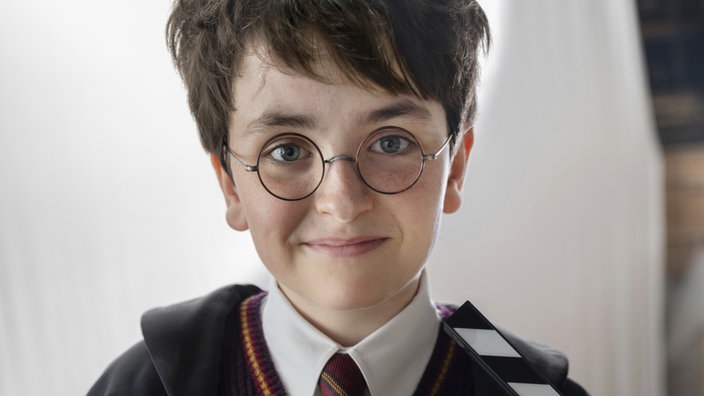 Der schottische Schauspieler Dominic McLaughlin mit runder Brille bei Dreharbeiten am Set der Harry-Potter-Serie in der Nähe von London in Großbritannien. 