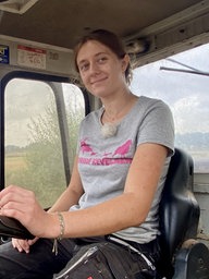 Frau sitzt im Radladerund lächelt