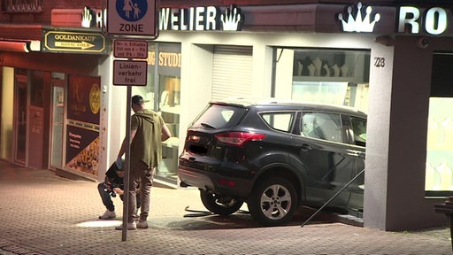 Ein Auto hat ein Schaufenster durchbrochen und steht mit der Fron in einem Juwelierladen