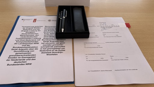 Ein aufgeschlagenes Dokument, die Vereinbarung zwischen deutscher und niederländischer Polizei.