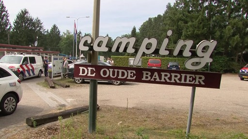 Schild eines Campingplatzes vor einem Parkplatz