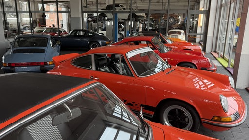 Porsche-Oldtimer stehen nebeneinander in einer Autowerkstatt