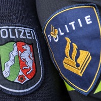 Die Wappen der deutschen und niederländischen Polizei auf zwei Uniformärmeln nebeneinander