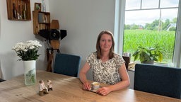 Sabine Derieth, die Angehörige eines Unfallopfers, sitzt mit einer Tasse Kaffee am Tisch.