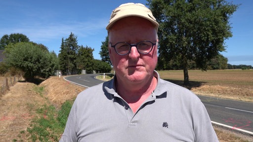 Anwohner Ernst van Wickeren steht an einer gefährlichen Straße in Weeze und beobachtet den Verkehr.