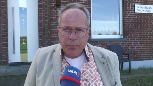 Constant Koopal schaut direkt in die Kamera. Vor ihm befindet sich ein WDR-Mikrofon.