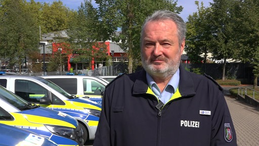 Stefan Sparberg von der Polizei Kleve trägt eine dunkelblaue Jacke mit der Aufschrift "Polizei"
