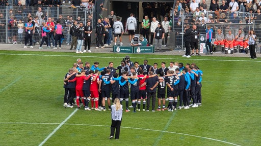 Die St. Tönis Spieler bilden nach Abfiff einen Teamkreis und verabschieden sich von den Fans