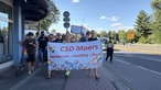 Der Demozug beim CSD in Moers mit einem Plakat, auf dem steht "CSD Moers. Gemeinsam. Vielfältig. Stark"