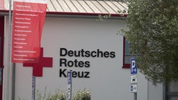 Das Logo des Deutschen Roten Kreuz auf einer weißen Fassade. 