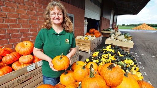 Judith Schäfer vom Hof in Hamminkeln tragt ein grünes Oberteil und hat einen Kürbis in der Hand.