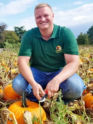 Landwirt Hermann Schäfer links im Bild und Obstbaumeister Henrik Schäfer rechts daneben hocken im Kürbisfeld.