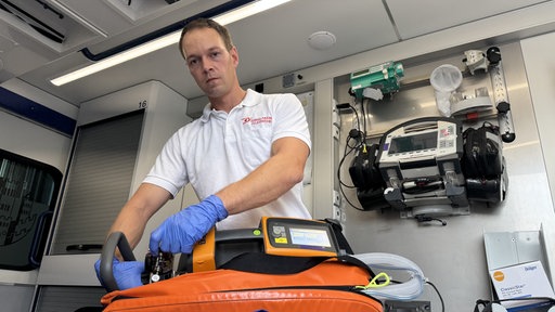 Rettungssanitäter Matthias kontrolliert Geräte im Rettungswagen