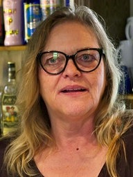 Gastronomin steht vor einer Bar 