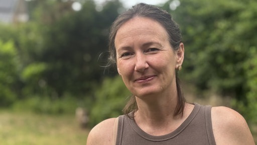 Frau mit braunem Top vor Wald