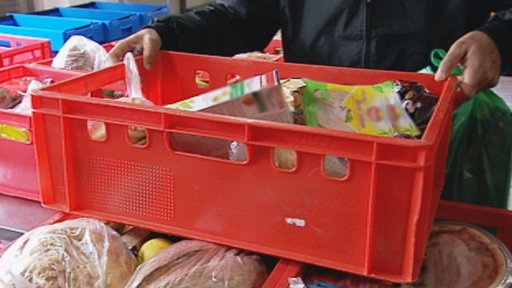 Eine Plastikkiste mit Nahrungsmitteln wird weggetragen