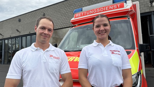 Team Matthias und Jana posieren vor ihrem Rettungswagen in Dinslaken