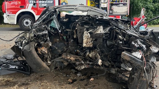 Vollständig zerstörtes Auto mit aufgerissener Fahrerseite