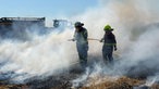 Zwei Feuerwehrfrauen stehen mit einem Wasserschlauch in einer Rauchwolke