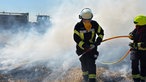 Eine Feuerwehrfrau mit einem Wasserschlauch in der Hand