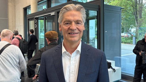 Friedrich-Hans Grandin steht in der Eingangshalle. Es ist Präsident vom Nordwestdeutschen Textilverband.