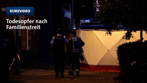 zwei Polizisten vor Tatortsichtschutz