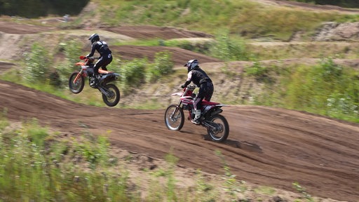 2 Personen auf Motocross- Rädern auf einer Piste, Jeanette Hauswirth rechts