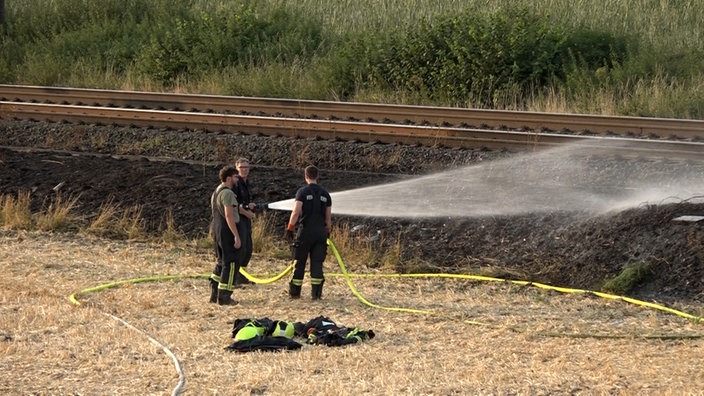Drei Feuerwehrleute bei den Löscharbeiten. 