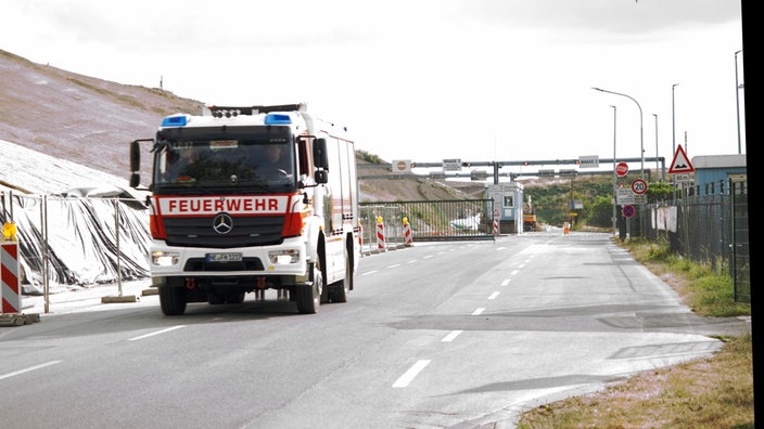 Feuerwehrauto vor einer Mülldeponie