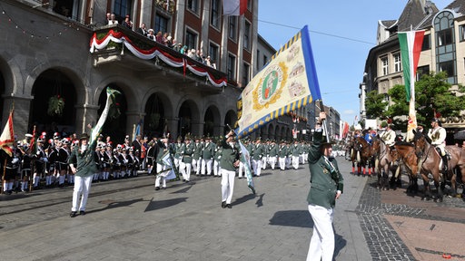 Mehrere Schützen in grün-weißer Uniform beim Neusser Schützenfest