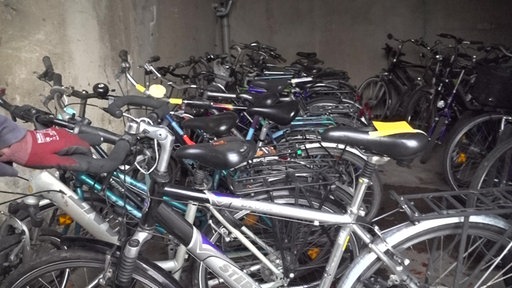 Mehrere Fahrräder stehen in einer Reihe in einer Garage