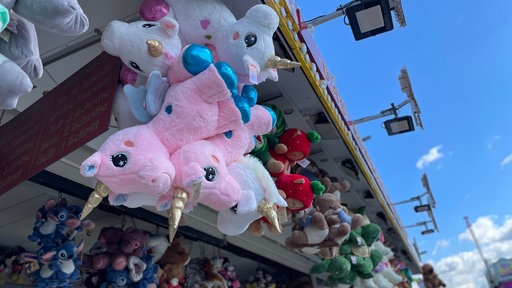 Stofftiere hängen vor einem Stand