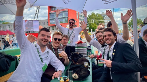 Eine Gruppe junger Männer sitzt an einem Tisch
