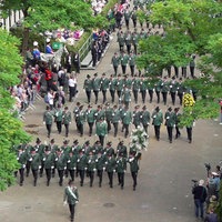 Schützen marschieren beim Schützenfest in Neuss. Sie haben grüne Uniformen an, das Bild ist aus einer erhöhten Position aufgenommen.