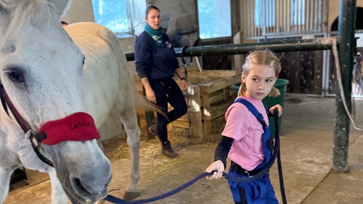 Eine Frau mit einem Kind und einem Pferd