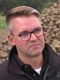 Landwirt Florian Oymans neben einem Zuckerrübenhaufen