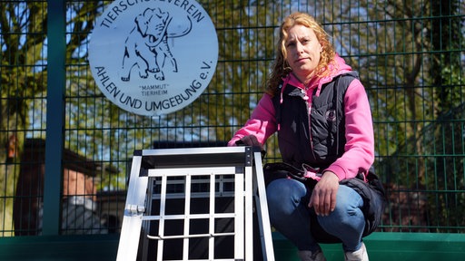 Frau vor Hundekäfig