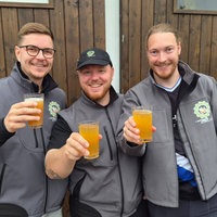 Drei Männer halten Gläser mit Apfelwein in der Hand