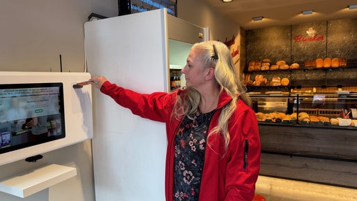 Eine Frau benutzt den Apothekenschalter in einer Bäckerei.