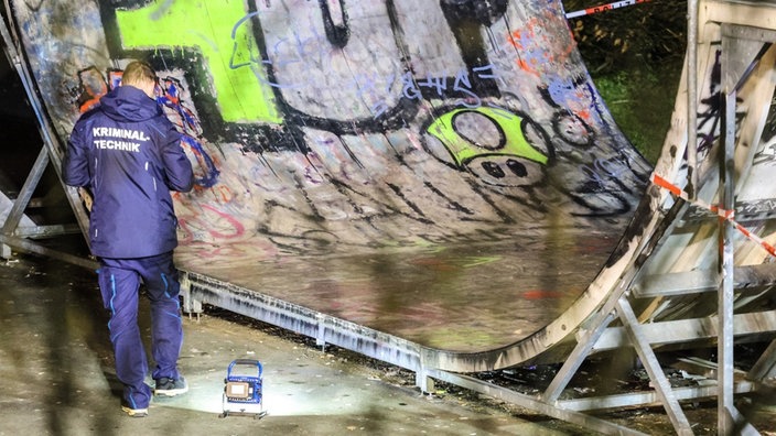Ein Kriminaltechniker untersucht eine Halfpipe in einem Skatepark