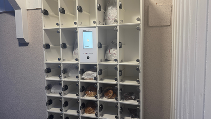 Ein Brotautomat, der an einer Wand hängt.