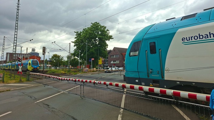 Der Bahnübergang mit runtergelassenen Schranken
