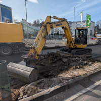 Inklusive Bagger beginnt die Sanierung einer Straße.