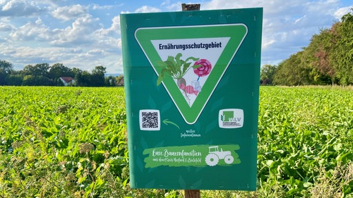 Im Feld steht ein Schild mit der Aufschrift "Ernährungsschutzgebiet"