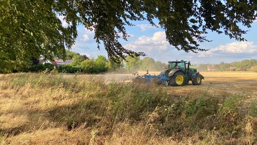Ein Traktor fährt über das Feld