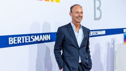 Thomas Rabe vor einem Banner der Bertelsmann AG
